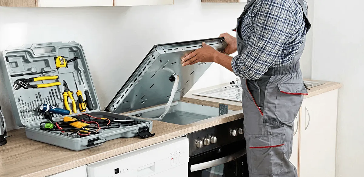 Handyman repairing a cooktop and checking wiring connections in Minneapolis, MN