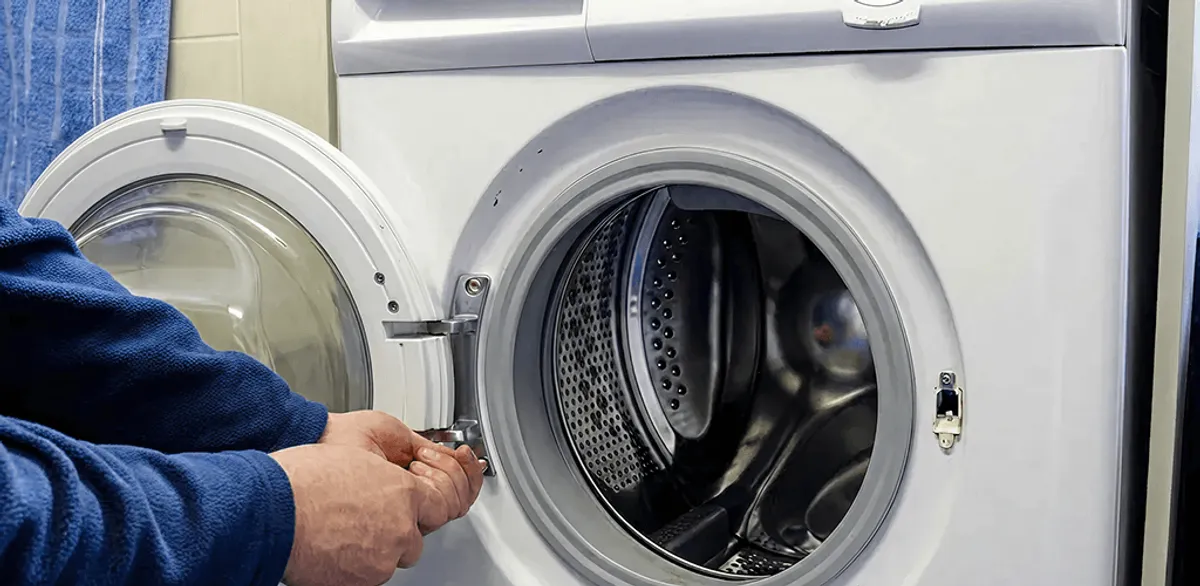 Washing machine repair handyman checking a front-load washer door and latch in Minneapolis, MN