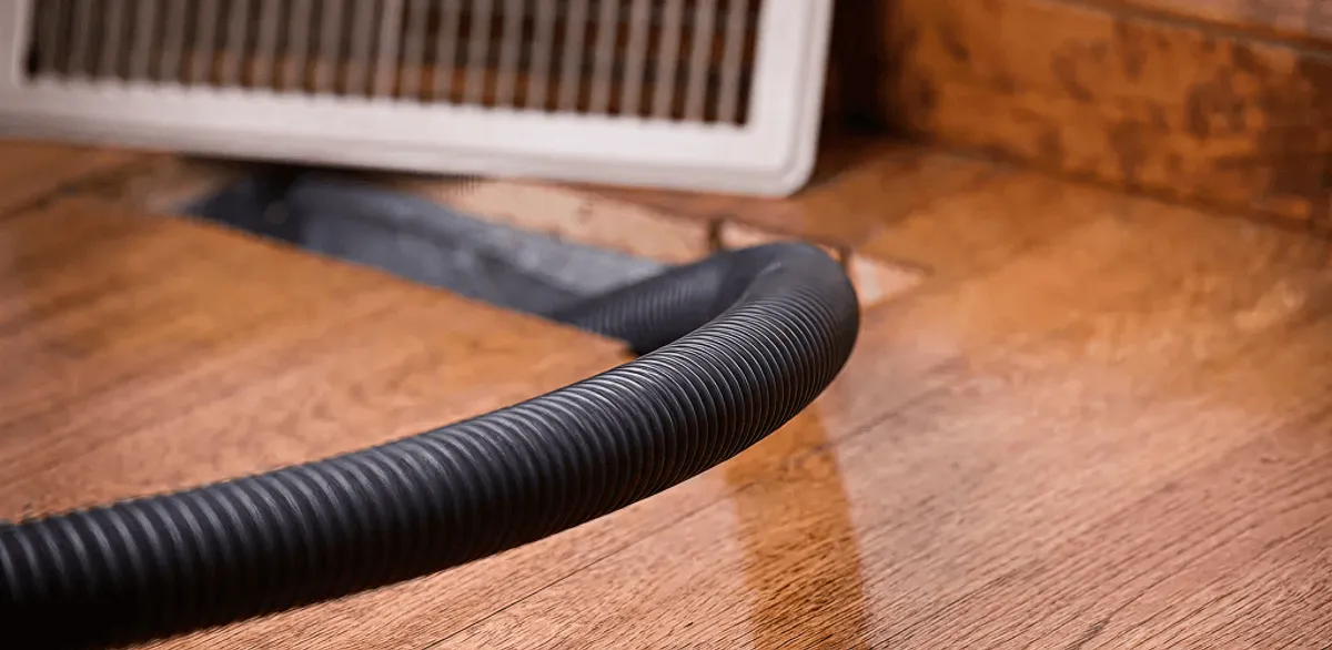 Air duct cleaning hose inserted into a floor vent for ductwork cleaning in Minneapolis, MN